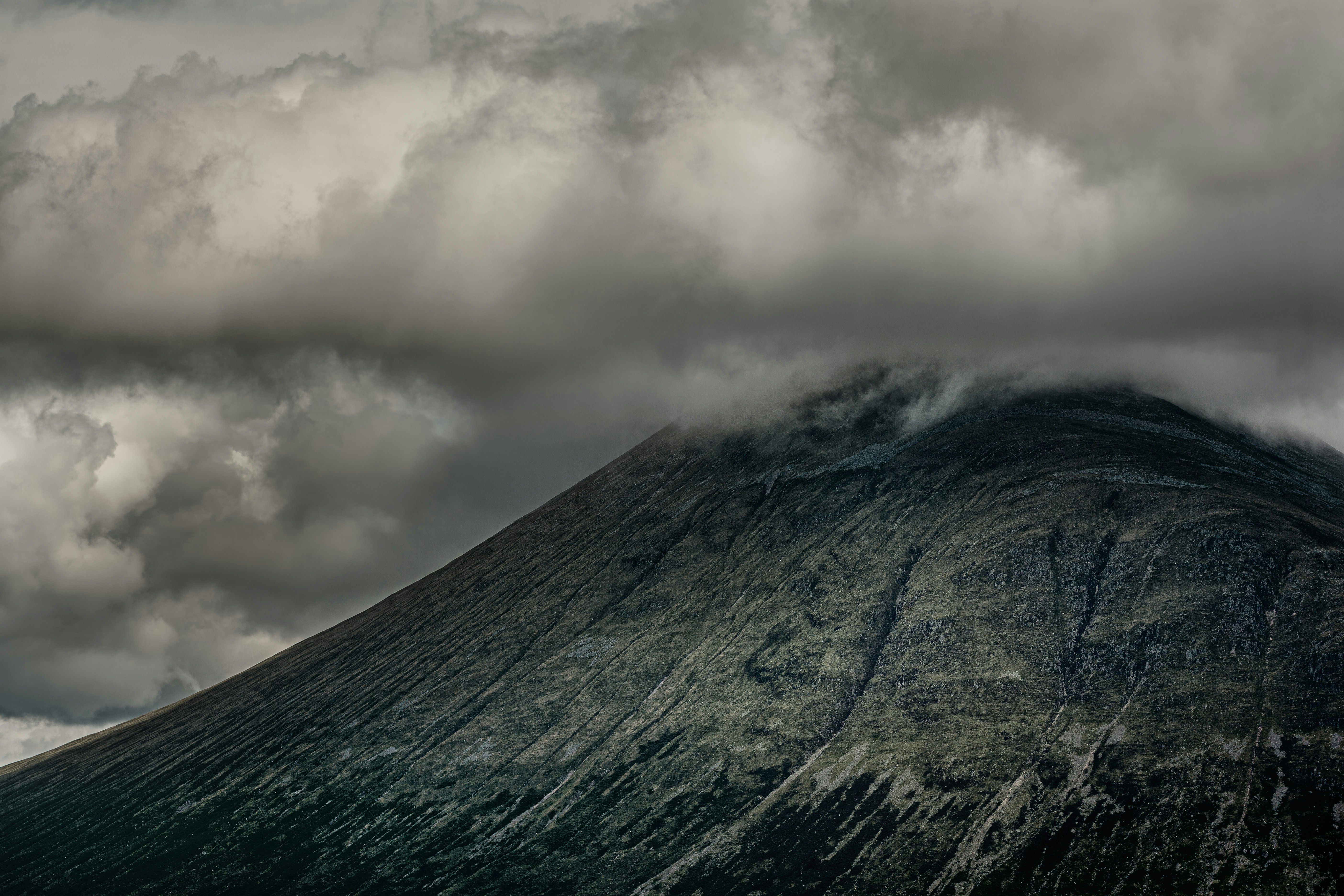 gray and white clouds over green and gray mountain